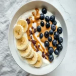 Yogurt Bowl with Banana, Blueberries, and Peanut Butte First Image First Image